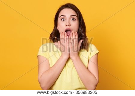 Close Up Portrait Of Astonished Woman With Widely Open Mouth, Being Amazement, Stands With Big Eyes,