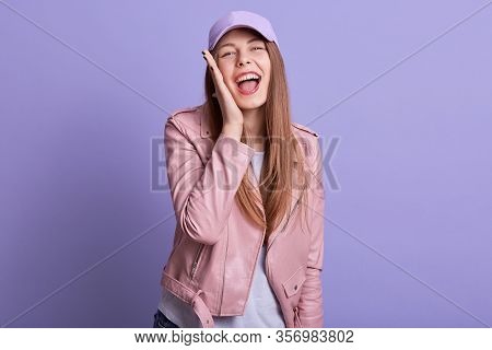 Picture Of Attarctive Woman Dresses Leather Pink Jacket And Cap Cavering Ear With Palm Screaming Som