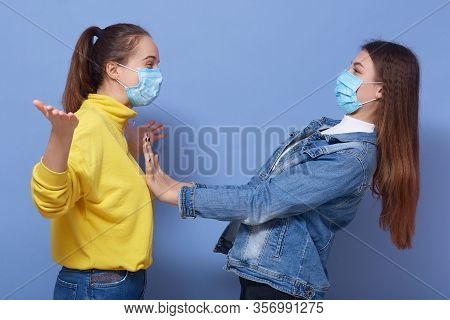 Adorable Female Don't Want To Contact With Her Friend Wearing Yellow Shirt And Mask, Trying To Avoid