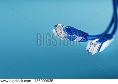 Two Ethernet Cable Connectors Patch Cord Cord Close-up Isolated On A Blue Background With Free Space
