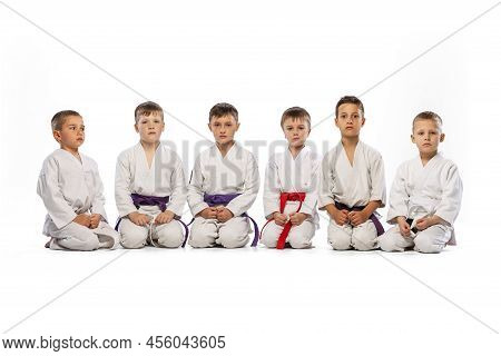 Little Beginner Karate Fighters In White Doboks And Colorful Belts Training Isolated On White Backgr