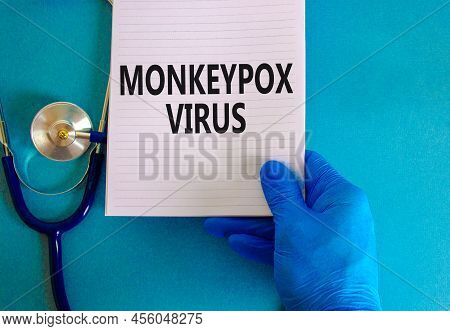 Monkeypox Virus Symbol. Concept Words Monkeypox Virus On White Note. Stethoscope. Doctor Hand In Blu