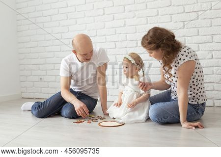 Child Girl With Cochlear Implant Plays At Home With Mother And Father. Hear Impairment And Diversity