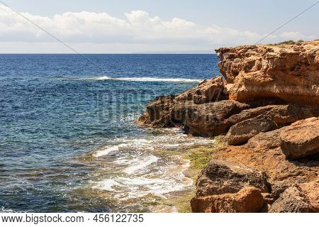 Krast Cape Cliffs Stretching Into The Blue Mediterranean Sea In Ibiza, Balearic Islands, Spain