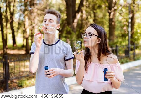 Two Teenagers Having A Good Time In The Park On A Beautiful Sunny Summer Day, Blowing Bubbles. Free 