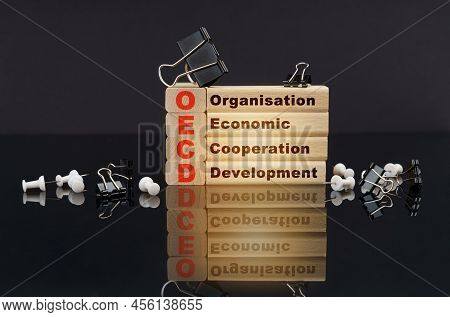 Business Concept. On A Black Reflective Surface, Buttons, Clips And Wooden Blocks With The Inscripti
