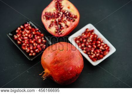 Sliced Red Pomegranate On A Black Slate