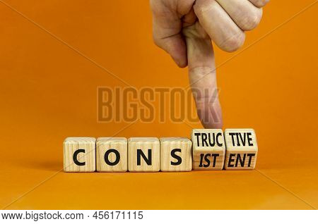 Constructive Or Consistent Symbol. Businessman Turns Cubes, Changes The Word Consistent To Construct