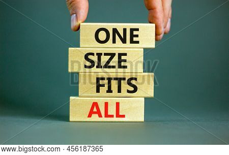 One Size Fits All Symbol. Concept Words One Size Fits All On Wooden Blocks. Businessman Hand. Beauti