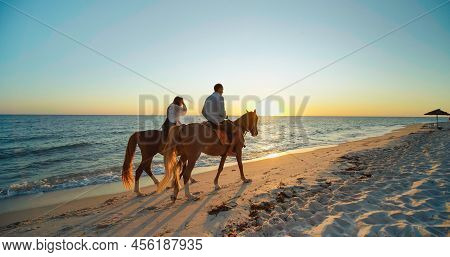 Monastir, Tunisia, 2022: Couple In Love Is Enjoying Holiday. Man And Woman Walks With Horses On The 