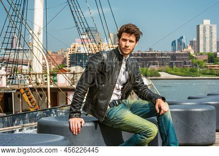 European Businessman Traveling In New York. Wearing Black Leather Jacket, Blue Jeans, A Young Guy Wi