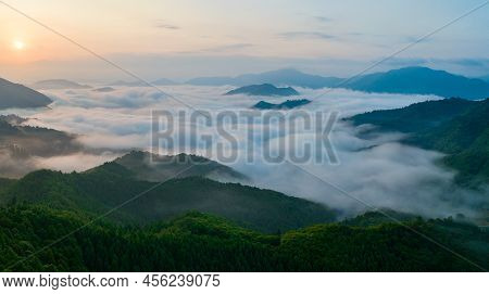 Sunrise Over Flowing Fog Between Mountain Peaks