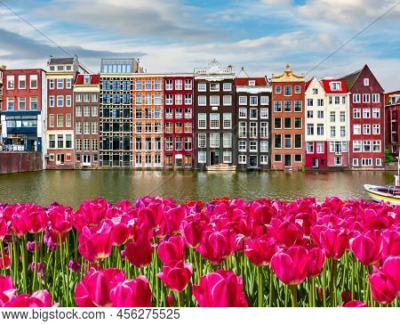 Traditional Amsterdam Architecture And Spring Tulips On Damrak Canal, Netherlands