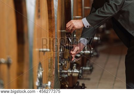 Senior Caucasian Tourist, Greybeard Elegant Man Tasting Red Wine In An Underground Wine Cellar Of Th