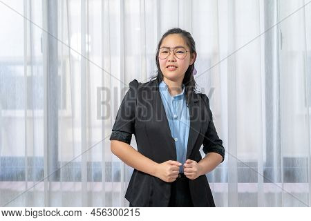 Little Entrepreneur Asian Eyeglasses Woman With Confident Pose In Black Suit Stands In Front Of Wind
