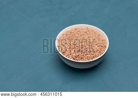 Lightly Sanded Devzira Rice In A Bowl. Selective Focus, Blue Background, Copy Space. Oriental Cuisin