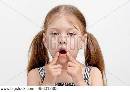 Child With Open Mouth And Fingers On Mouth Corner
