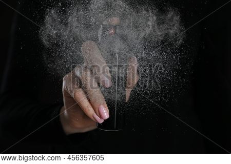 Young Woman Using Pepper Spray On Black Background, Closeup