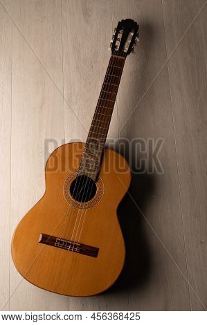 Classical Guitar On A Light Wood Background