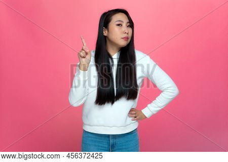 Serious Young Asian Girl Raised Finger Up, Warning, Says You Must Be Attentive. Admonishing Gesture,