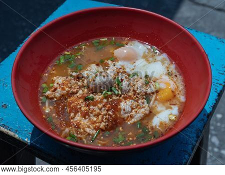 Spicy Tom Yum Egg Noodles Soup With Shrimp Dumplings And Medium-boiled Eggs, Pork Slices And Pork Me