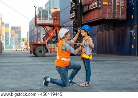 Father And Little Daughter Wearing A Safety Helmet At Container Cargo Site. Business Heir Concept. H