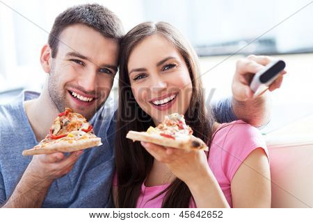 Pár s pizza a TV dálkové ovládání