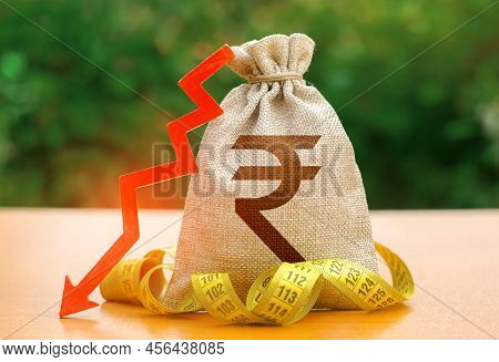 Indian Rupee Money Bag With Down Arrow And Measure Tape. Reduced Wages, Cuts In Social Benefits. Cut