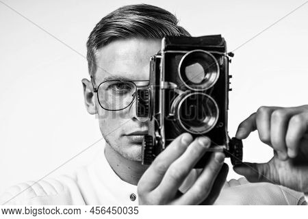 Young Photographer In Glasses Capture Image Looking In Eye Of Retro Camera Isolated On White, Shoot