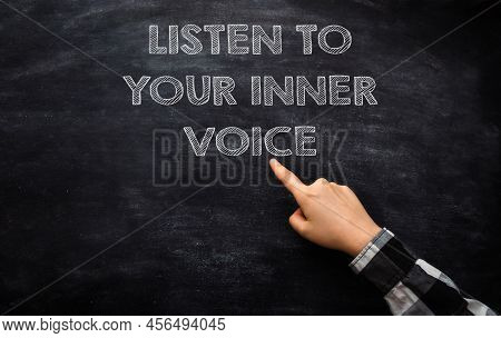 Coach Points To Listen To Your Inner Voice On Chalkboard