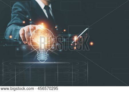 Light Bulb With Brain Inside The Hands Of The Businessman And Point Connecting Network Background. C