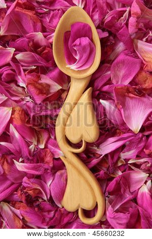 Bir arka plan bir kalp ile şekillendirme rose petal Çiçek Aranjman ahşap aşk kaşık. Rosa rugos