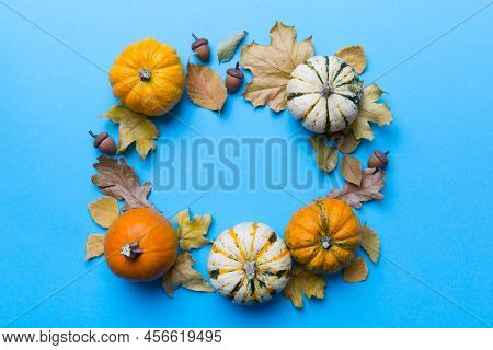 Autumn Composition Pumpkins With Fall Leaves Over Coloredbackground. Top View With Copy Space.