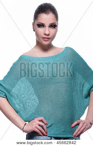 mladá neformální žena stojící s rukama v bok a při pohledu na fotoaparát, na bílé backgro