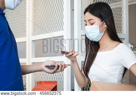 Young Asian Woman, Customer Wearing Face Mask Protect To Pandemic Of Covid And Use Mobile Phone Scan