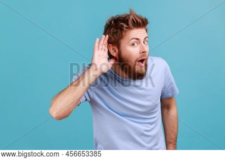 Cant Hear You. Portrait Of Attentive Bearded Man Holding Hand Near Ear Trying To Listen Quiet Conver