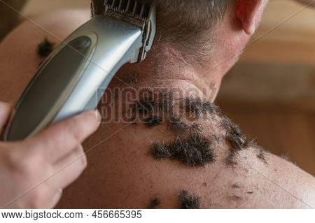 Adult Male's Back Is Sprinkled With Short, Cropped Hair. Person Sits With Naked Torso Inside The Liv