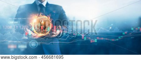 Hands Of Businessman And Gold Bitcoin Coin In Fire With Volatile Business Graph On Global Network, F