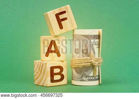 Business Concept. On A Green Surface, Dollars And Cubes With The Inscription - Fab