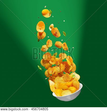 Potato Chips Falling Onto Plate On White Background. Advertising Concept. Levitation Flying Chips