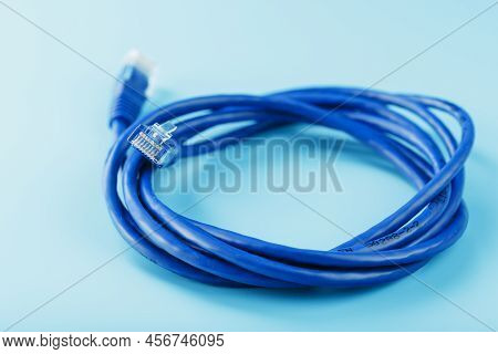 A Coil Of An Internet Network Cable For Data Transmission On A Blue Background