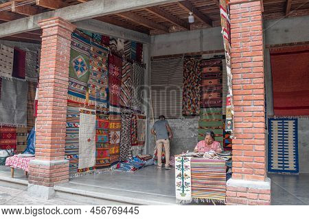 Teotitlan Del Valle, Oaxaca, Mexico- May 23, 2022: Woman Selling Traditional Handmade Rugs In Teotit