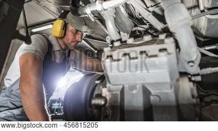 Caucasian Industry Mechanic In His 40s Performing Diesel Pusher Maintenance. Servicing Motor Coach.