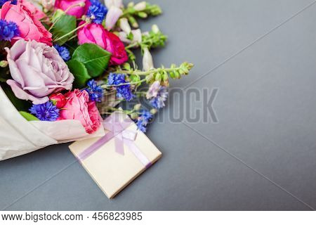 Close Up Of Summer Bouquet Of Roses Foxgloves Bachelor Buttons Flowers Wrapped In Paper And Arranged