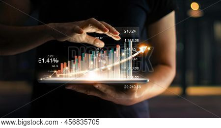 Businessman Holding Tablet And Showing A Growing Virtual Hologram Of Statistics, Graph And Chart Wit