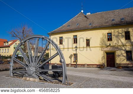 Eisleben, Germany - March 21, 2022: Industrial Wheel And Coal Carts In Front Of A Historic Building 