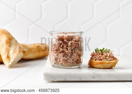 Toasts With Tuna Pate Or Rillettes On White Board With Baguette. Glass Jar With Fish Rillettes. Clos