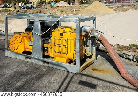 Large Yellow Portable Electric Water Pump With Hose For Dewatering The Deep Pit Of The Building Foun