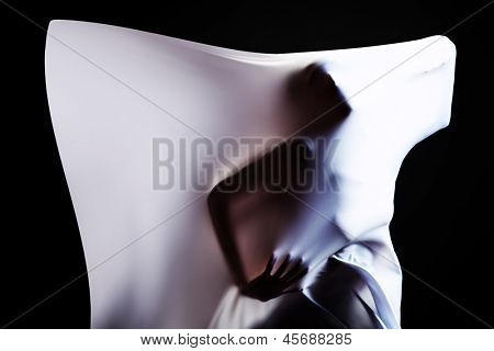 Art photo of a women silhouette breaking through the fabric. Struggle concept.