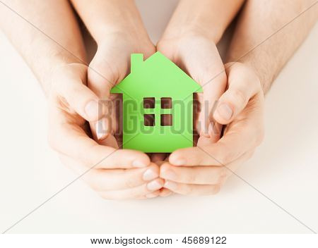 Close-up foto van vrouw en man handen met groen huis